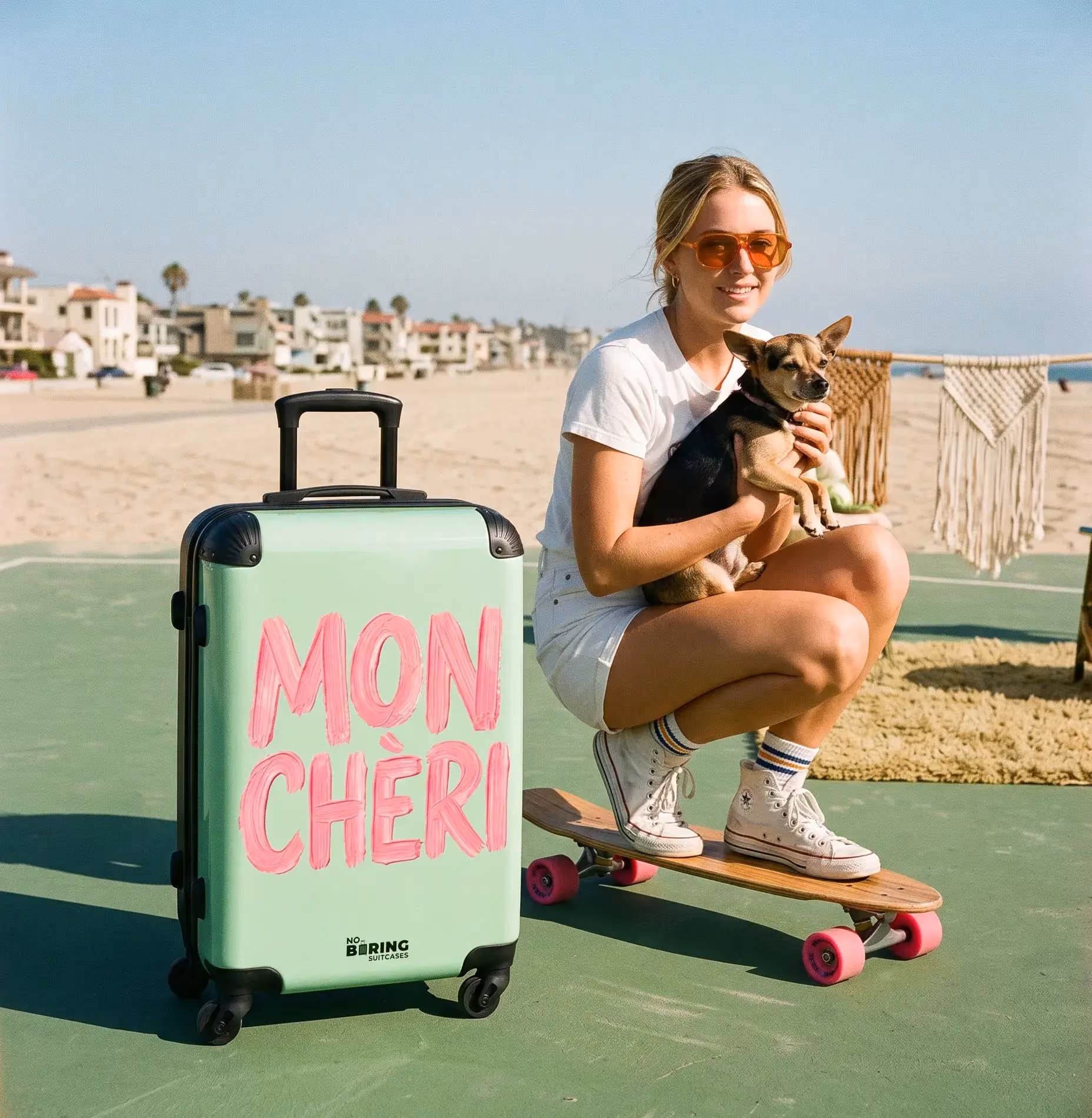 A cabin suitcase next to a woman on a skateboard with a dog in hand
